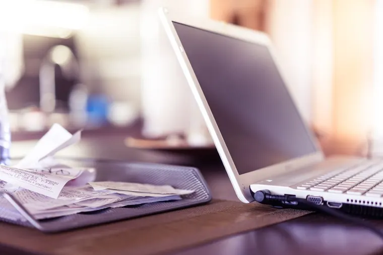 desk with laptop and receipts