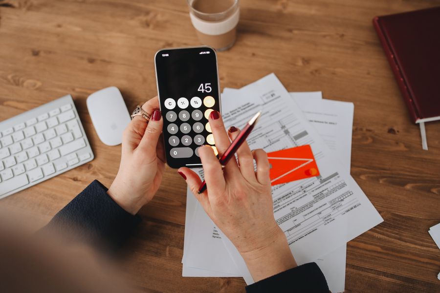 person calculating on phone at desk