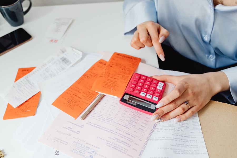 person calculating with receipts and papers